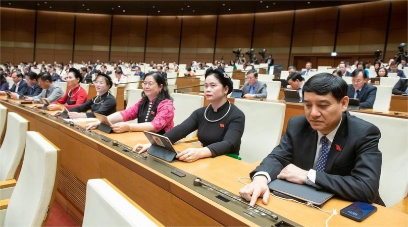 Vietnamese lawmakers press the buttons to approve the resolution on resumption of the nuclear power project in Ninh Thuan province.