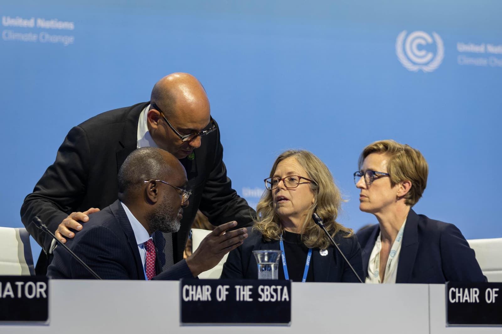 UNFCCC Executive Secretary Simon Stiell speaks with Adonia Ayebare, SBSTA Chair, and Julia Gardiner, SBI Chair. Credit: IISD/ENB – Kiara Worth