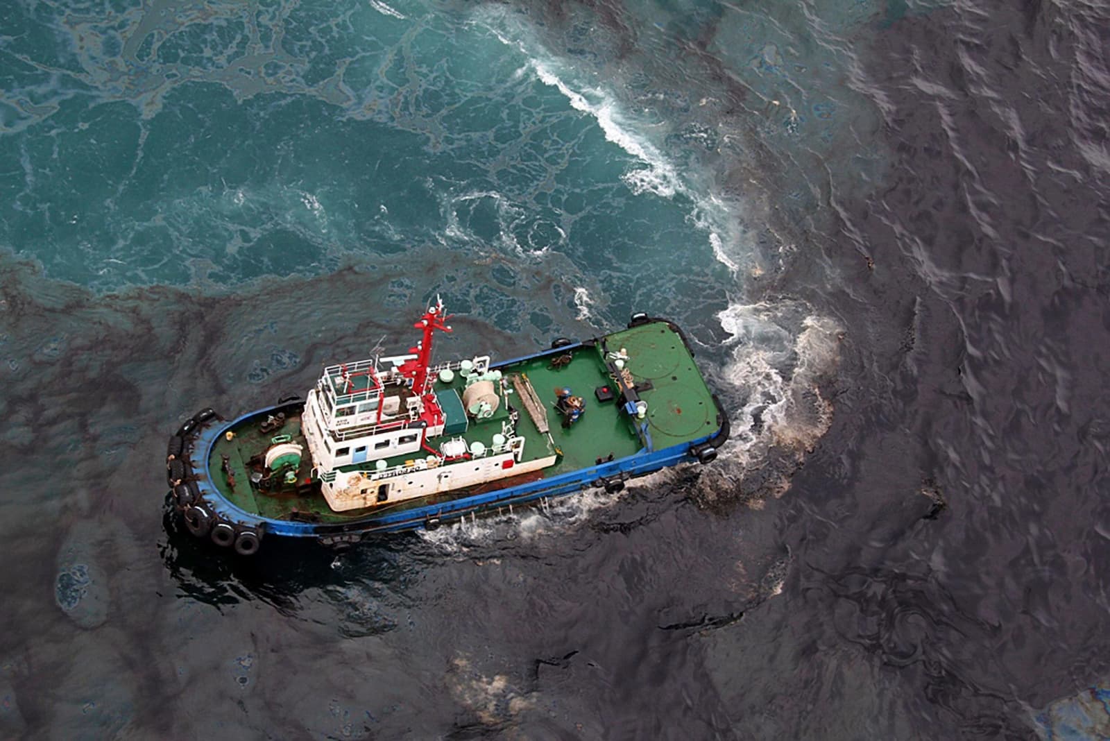 A vessel participating in the cleanup of an oil spill off the coast of Rayong province in 2013, caused by a pipeline leak (Image: Associated Press / Alamy)
