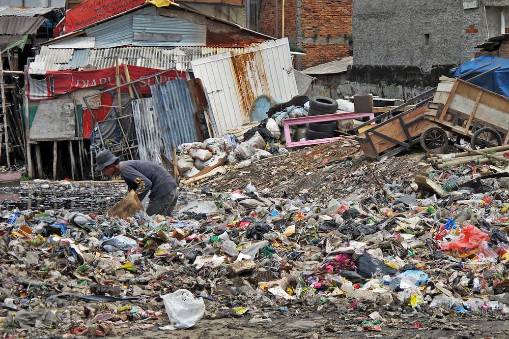 A man sifts through garbage in Jakarta. Image by Farhana Asnap / World Bank via Flickr (CC BY-NC-ND 2.0).