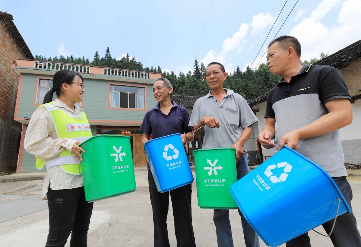 A volunteer introduces garbage sorting to villagers in Gulong village, Guangxi province (Image: Imaginechina / Alamy)